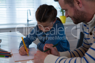 Father assisting daughter in her studies
