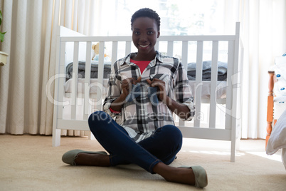 Portrait of pregnant woman holding baby socks