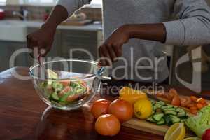 Mid section of woman preparing salad