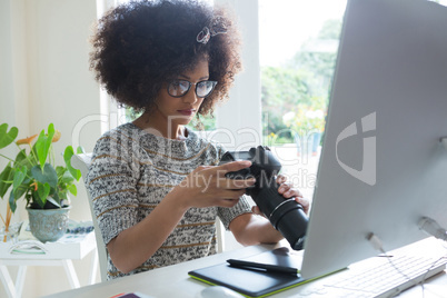 Graphic designer reviewing pictures on digital camera