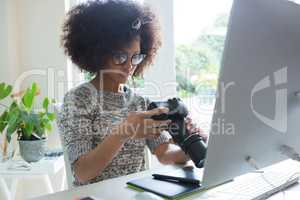 Graphic designer reviewing pictures on digital camera