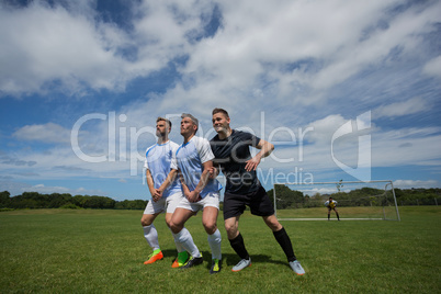 Football players playing soccer in the ground