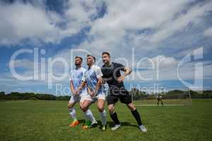 Football players playing soccer in the ground