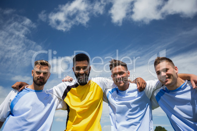 Football players standing together with arm around