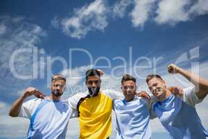 Excited football players standing together with arm around