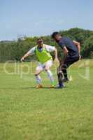 Football players dribbling the soccer on the football ground