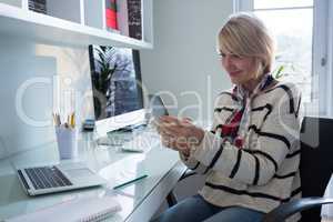 Woman using mobile phone at table