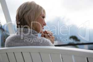 Rear view of thoughtful woman relaxing in porch