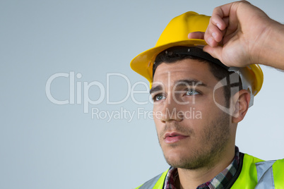 Male architect holding hard hat against white background