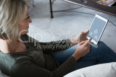 Beautiful woman using digital tablet in living room