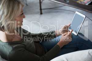 Beautiful woman using digital tablet in living room