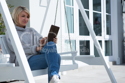 Beautiful woman using digital tablet in porch