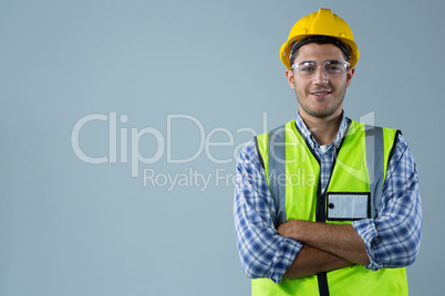 Male architect standing with arms crossed against white background