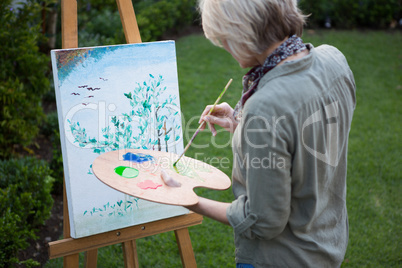 Woman painting on canvas