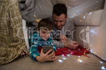 Father and son using mobile phone