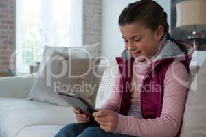 Cute girl using digital tablet in living room