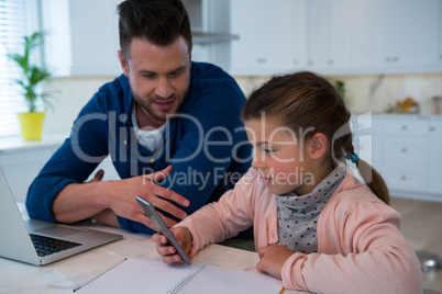 Father and daughter using mobile phone