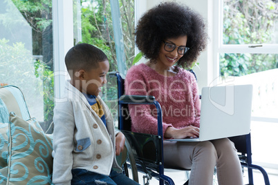 Son and his disabled mother using laptop