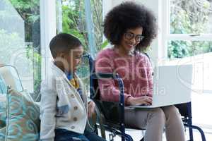 Son and his disabled mother using laptop