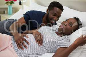 Man touching woman stomach in bedroom