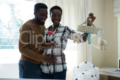 Happy man and pregnant woman holding a toy