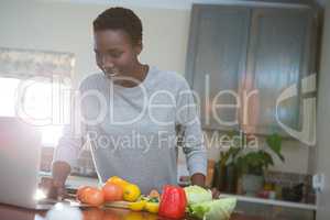 Beautiful woman learning food recipe from laptop