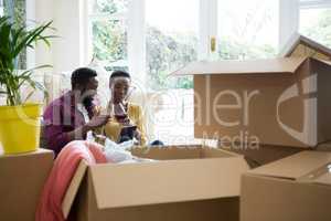 Couple having wine while using digital tablet