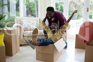 Man carrying woman in cardboard box