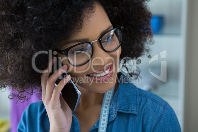 Female fashion designer talking on mobile phone