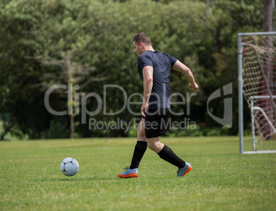 Football player dribbling the soccer on the football ground