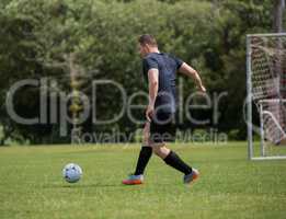 Football player dribbling the soccer on the football ground