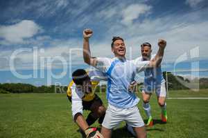Excited football players celebrating after scoring goal