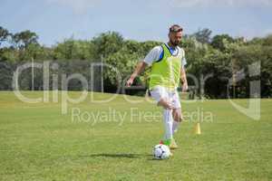 Football player dribbling the soccer on the football ground