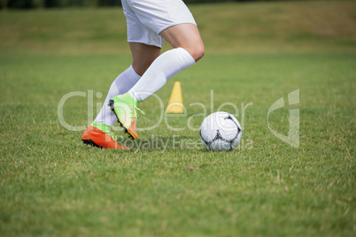 Football player dribbling the soccer on the football ground