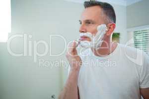 Man applying shaving foam on his face