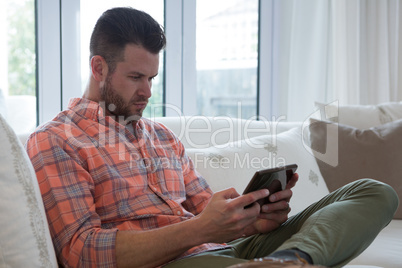 Man using digital tablet in living room