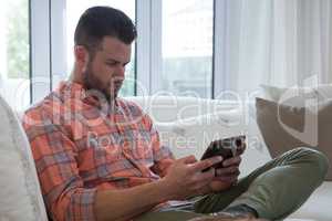 Man using digital tablet in living room