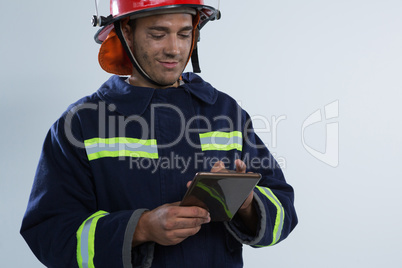 Fireman using digital tablet against white background