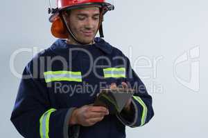 Fireman using digital tablet against white background