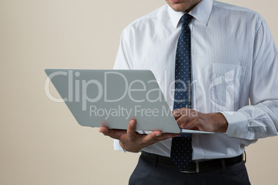 Executive using laptop against white background