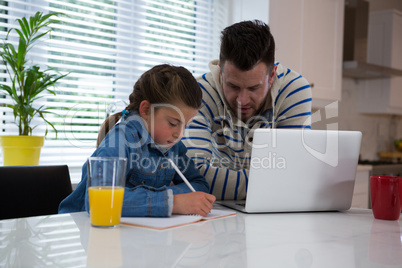 Father assisting daughter in her studies