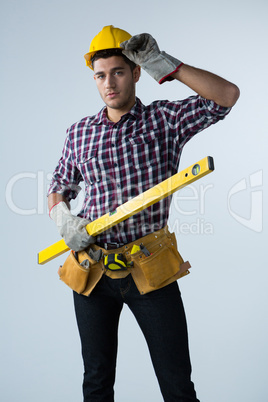 Male architect holding measuring equipment against white background