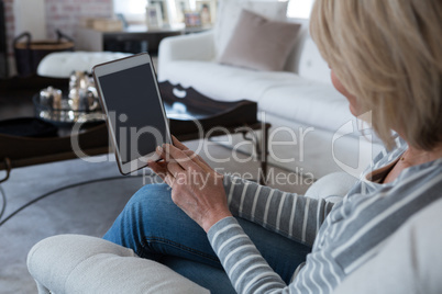 Woman using digital tablet in living room
