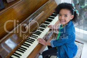 Adorable girl playing piano