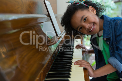 Girl playing piano with digital tablet