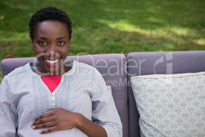 Pregnant woman touching her stomach in garden