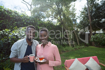 Couple having lemon tea and black coffee in garden