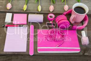 Female accessories, stationery and coffee on wooden surface