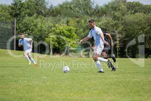 Football players playing soccer in the ground