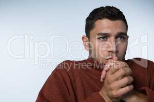 Man in sweater shivering against white background